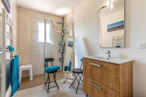 a bathroom with a sink and two stools in front of a shower at Villa du Lac in Gastes +15 photos