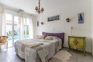a bedroom with a bed with a table and windows at Villa du Lac in Gastes