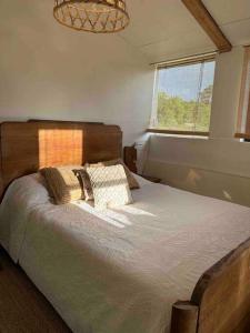 a bedroom with a bed with two pillows and a window at Cosy Cabane Boise solaire, Balneo bath et toilette seche a la Ferme in Mimizan