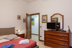 - une chambre avec un lit et une télévision sur une commode dans l'établissement Casa Umbé, à Pietrasanta