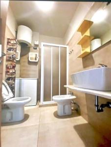 La salle de bains est pourvue d'un lavabo blanc et de toilettes. dans l'établissement Ca' Dei Pescatori dalle spiagge Lavagna, à Lavagna