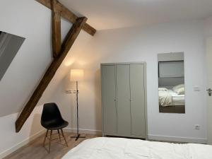 a bedroom with a bed and a chair and a mirror at Apartment mit Jacuzzi Enschede 10km in Gronau