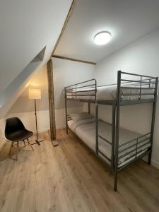 two bunk beds in a room with a lamp and a chair at Apartment mit Jacuzzi Enschede 10km in Gronau