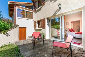 eine Terrasse mit roten Stühlen und einem Glastisch in der Unterkunft A la belle étape in La Fouillouse