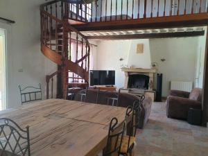 sala de estar con mesa de madera y escalera en Villa Montady, en Montady