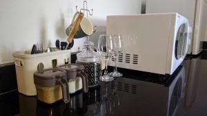 a kitchen counter with a toaster and wine glasses at A lovely studio apartment with gym and pool access in Dar es Salaam