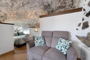 ein Wohnzimmer mit einem Sofa und einem Bett in der Unterkunft Cueva El Desvelo in Tijarafe