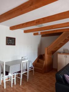 een woonkamer met een tafel en stoelen en een trap bij Holiday Home Loznati in Cres