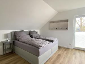 Ce lit se trouve dans un dortoir blanc doté d'une grande fenêtre. dans l'établissement Seeglück 2 am Tollensesee, à Groß Nemerow