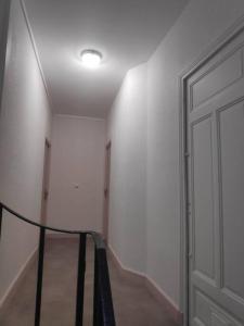 a hallway with a white wall and a door at 2 Apparts, Riom, 8 pers in Riom