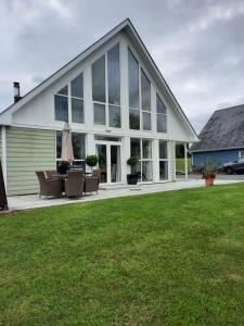 a large white house with windows and a lawn at Stunning 55 Riverun on the banks of the lovely Riv in Belturbet