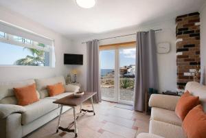 uma sala de estar com um sofá e vista para o oceano em Casa Karma em Arico