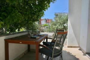 a wooden table and chairs sitting on a balcony at Apartments Antea in Trogir