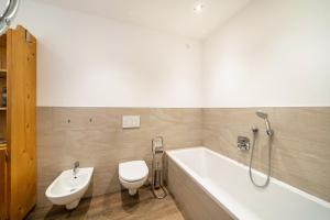 a bathroom with a tub and a toilet and a sink at Haus Reimon Apt Monika in San Leonardo in Passiria +12 photos