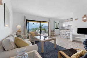 La Villa La Palma- 2 dormitorios A في Los Barros: غرفة معيشة مع أريكة وطاولة