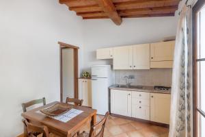 una cucina con un tavolo e un frigorifero bianco di Appartamenti i Tigli 2 a Capoliveri Altre 10 foto