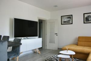 a living room with a flat screen tv and a couch at Apartments Antea in Trogir