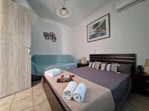 a bedroom with a bed with towels and a couch at Afroditi's 2 in Eresos