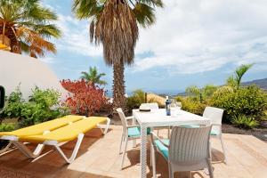 a patio with a table and chairs and a yellow bench at Villa Verde Superior A in Los Barros