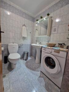 a bathroom with a washer and a toilet and a sink at Afroditi's 2 in Eresos +115 photos