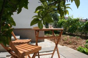 a wooden table and a wooden chair next to a table at Apartments Antea in Trogir