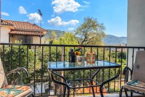 a table and chairs on a balcony with a view at Milina's Cozy Riverside Apartments in Milina