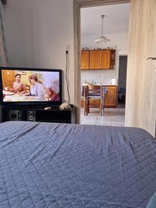 a bedroom with a bed and a flat screen tv at Afroditi's 2 in Eresos
