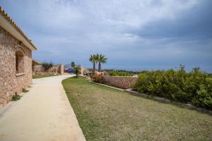 a walkway in front of a house with palm trees at Dammuso Ignazio in Lampedusa