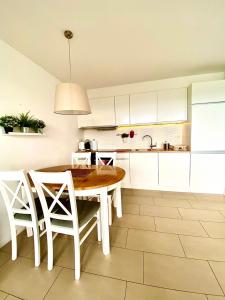 a kitchen with a wooden table and white cabinets at Bukove Love in Wisła +16 photos