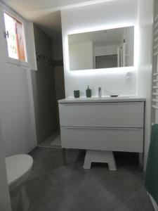 ein weißes Bad mit einem Waschbecken und einem WC in der Unterkunft Gite de pernaout in Bélis