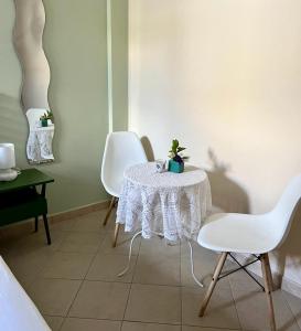 een kamer met een tafel en twee witte stoelen bij B&B Buongiorno Salento in Patù
