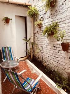 d'une terrasse avec une table, une chaise et un mur en briques. dans l'établissement Kambô hostel, à São Paulo
