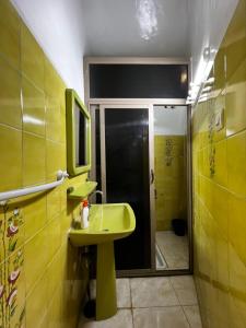 y baño con lavabo amarillo y ducha. en Riad Del Rey en Rabat