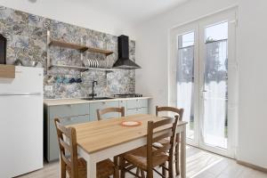 Fiumaretta di AmegliaAppartamento 3的配有桌椅和冰箱的厨房