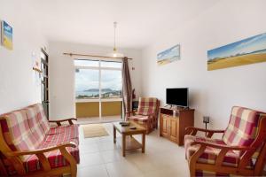 Una sala de estar con dos sillas y un televisor. en Cantinho Solpraia, en Porto Santo