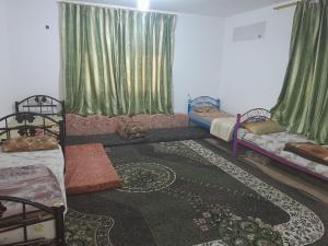 a room with two beds and green curtains at منزل ابو يوسف القضاه in Ajloun