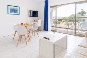 a living room with a table and chairs and a large window at Mar Hotels Alcanada in Port d'Alcudia
