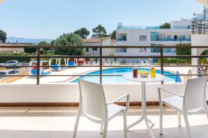 a table and chairs on a balcony with a view of a pool at Mar Hotels Alcanada in Port d'Alcudia
