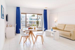een woonkamer met een bank en een tafel en stoelen bij Mar Hotels Alcanada in Port d'Alcudia