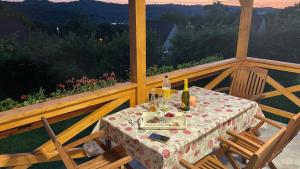 a table with a bottle of wine on a porch at Naplemente Vendégház in Orfű