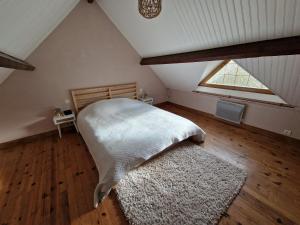 una camera da letto con letto e finestra in mansarda di Maison de campagne à Conie-Molitard (1h30 de Paris) a Conie-Molitard