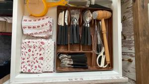 a drawer filled with utensils in a cabinet at Naplemente Vendégház in Orfű