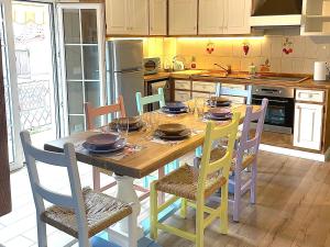 eine Küche mit einem Holztisch mit Stühlen und einer Küche in der Unterkunft Montinelle Apartament in Manerba del Garda