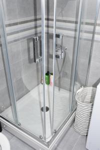 La salle de bains est pourvue d'une douche avec une porte en verre. dans l'établissement Apartman Get Rest, à Žabljak