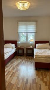1 Schlafzimmer mit 2 Betten und einem Fenster mit einem Kronleuchter in der Unterkunft Ferienzimmer zwischen Wien und Tulln in Tulln