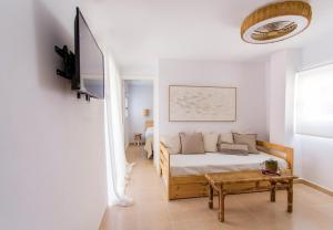ein weißes Schlafzimmer mit einem Bett und einem Tisch in der Unterkunft Alonis Suites Old Town - Trinitat 2 in Villajoyosa