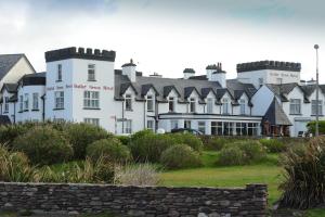 un gran edificio blanco con un cartel. en Butler Arms Hotel, en Waterville