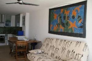 una sala de estar con sofá y una pintura en la pared en Première Ligne Avec Terrasse, en Mauguio