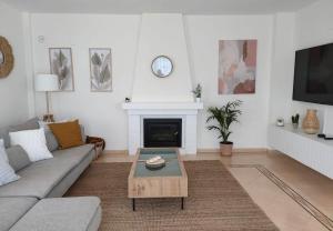 ein Wohnzimmer mit einem Sofa und einem Kamin in der Unterkunft Alonis Suites Premium Villas Onaer in Callosa d'en Sarrià