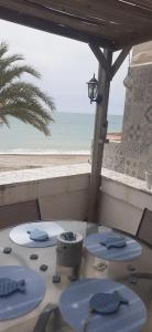 einen Tisch mit Stühlen und Blick auf den Strand in der Unterkunft Casa Rosita in Les Cases d'Alcanar
